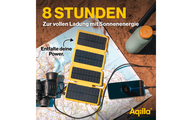 Acht zonnepanelen liggen op een bruine deken op een houten vloer, naast een smartphone en een USB-kabel