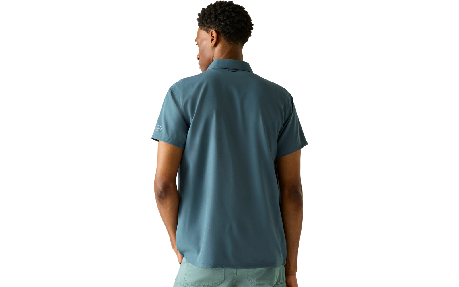 Person von hinten, trägt blaugrünes kurzärmeliges Poloshirt und hellgrüne Shorts vor hellem Hintergrund