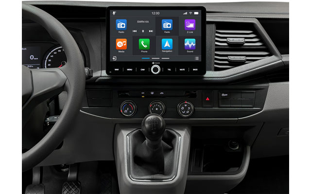 Innenraum eines Autos, Lenkrad links, mittiger Touchscreen mit App-Symbolen, Schalthebel für manuelles Getriebe, Klimabedienelemente und Lüftungsdüsen