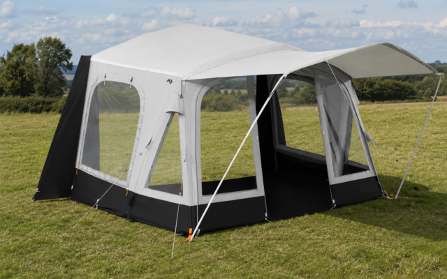 Wit-grijs campingluifel met zwarte onderrand, grote ramen, open ingang, steunstangen en scheerlijnen op een grasveld