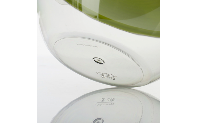 Vue inférieure d'un récipient en verre transparent rond avec un insert vert, une goupille métallique centrale, des marquages en relief et le texte "Made in Germany", reflété sur une surface blanche