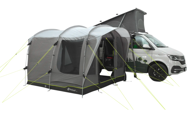 Ein graues Auto mit einem angehängten, grauen Campingzelt auf einer Wiese