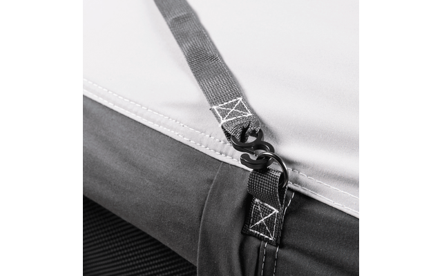 Close-up of fabric with stitched straps, visible seams, and two black hooks hooked into each other