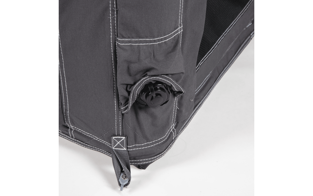 Close-up of a dark gray fabric corner with white stitching, a black plastic round valve and a strap with metal eyelet