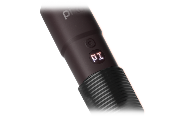 Gros plan d'un appareil cylindrique foncé avec poignée striée, bouton d'alimentation, petit affichage LED indiquant 'P1' et texte/logo partiellement visible en haut