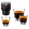 Bec d'une machine à café versant un espresso dans un petit verre double paroi; à côté, deux autres verres double paroi contenant de l'espresso