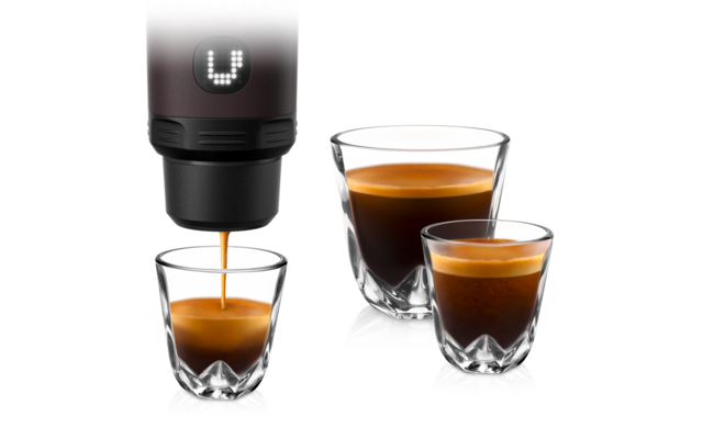 Bec d'une machine à café versant un espresso dans un petit verre double paroi; à côté, deux autres verres double paroi contenant de l'espresso