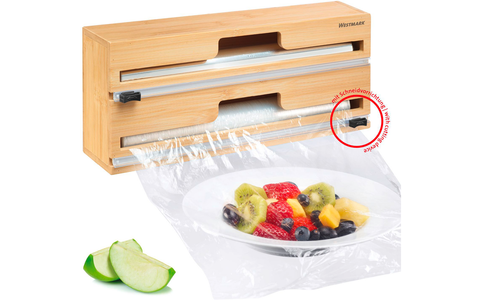 Caja de madera con dos soportes para rollos, film transparente cubriendo un plato blanco con ensalada de frutas, rodajas de manzana a la izquierda