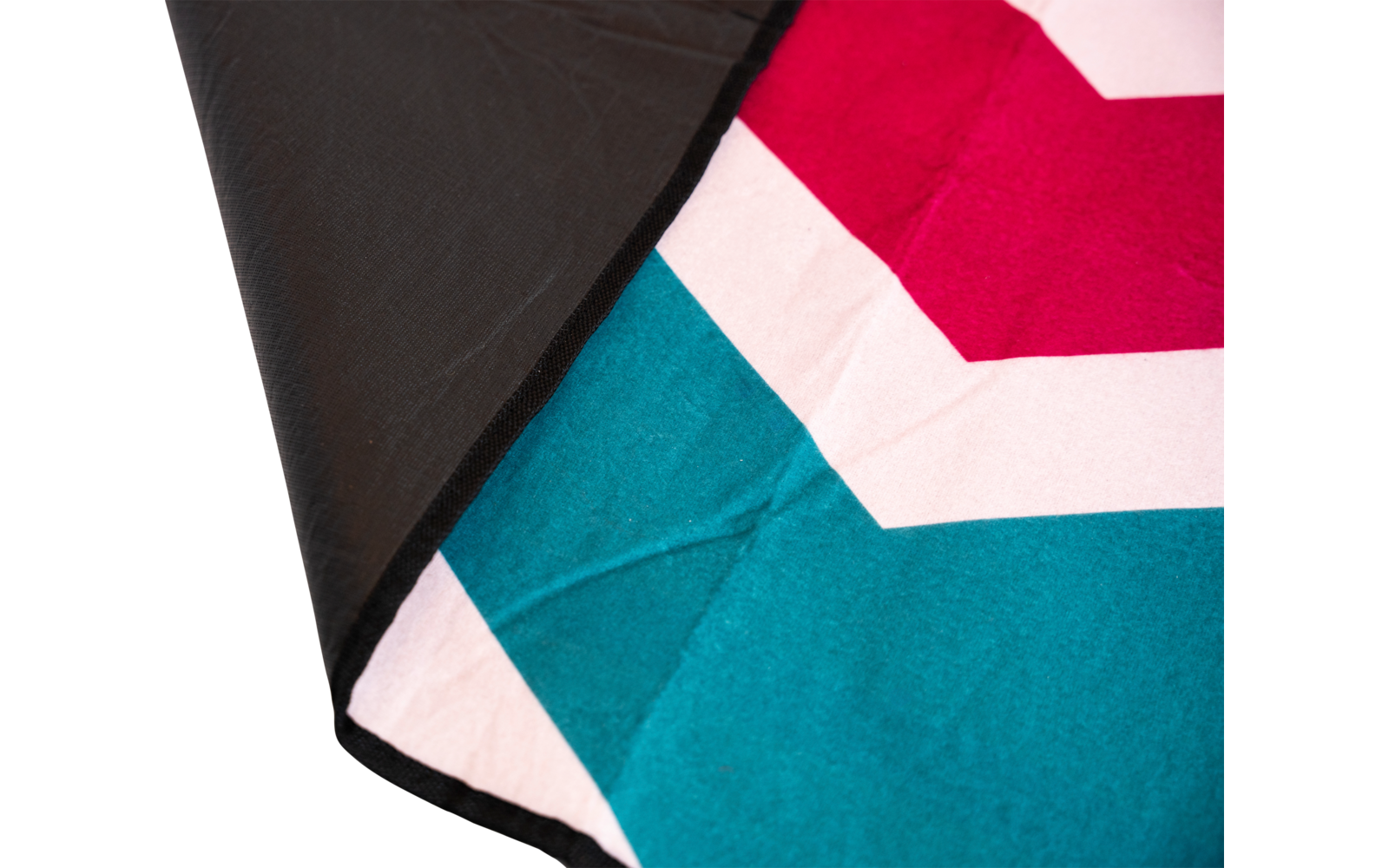 Gefaltetes Stoffstück mit gezacktem Muster in Magenta, Hellrosa und Blaugrün; schwarze Rückseite sichtbar