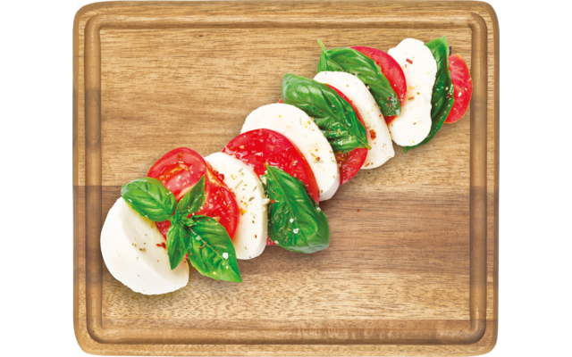Scheiben von Tomate, Mozzarella und Basilikum auf einem Holzbrett