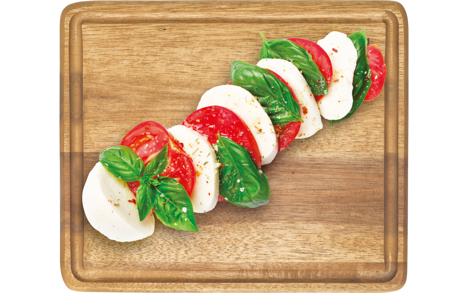 Scheiben von Tomate, Mozzarella und Basilikum auf einem Holzbrett