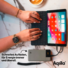 Een persoon die op een toetsenbord tikt voor een tablet, naast hen een koffiekopje op een marmeren tafel