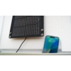 Panneau solaire au mur à côté d'un smartphone affichant l'état de charge