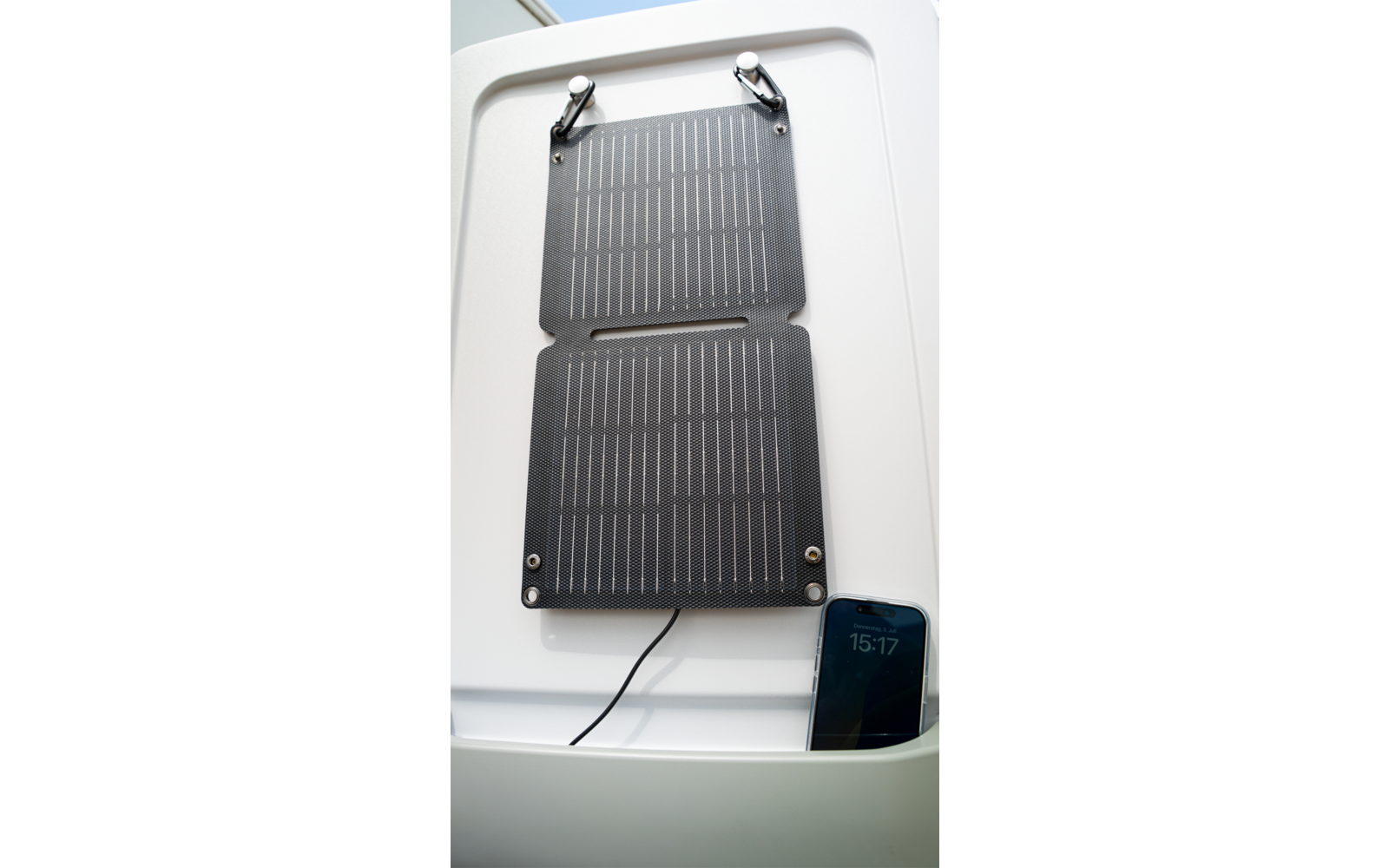 Panneau solaire noir sur fond blanc avec câble en bas