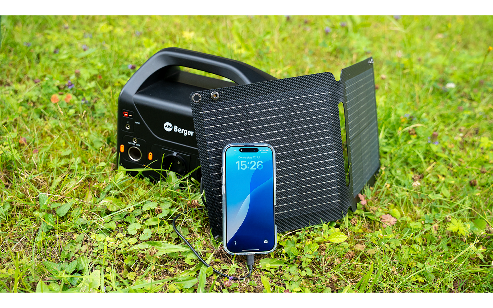 Tragbare Solarladegerät mit Smartphone auf Gras