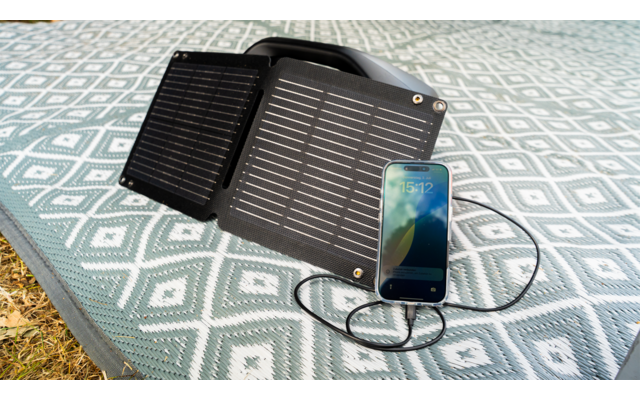 Solarpanel und Smartphone auf einem gemusterten Tisch