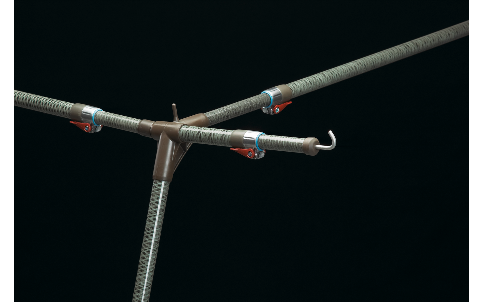 Drei strukturierte Metallrohre mit weißen Haken an den Enden, verbunden durch ein braunes Kunststoff-Zentralstück, mit kleinen roten Klammern, vor schwarzem Hintergrund