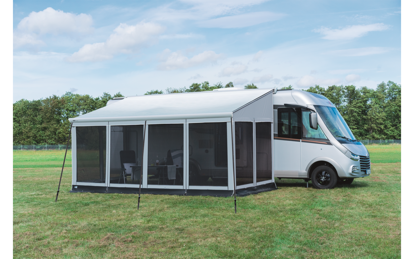 Wohnmobil mit angebautem, weißem Vorzelt auf grünem Gras