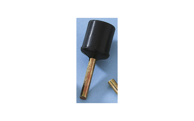 Black cylindrical cap on a gold-colored metal pin, next to a short cut metal piece on a light blue background