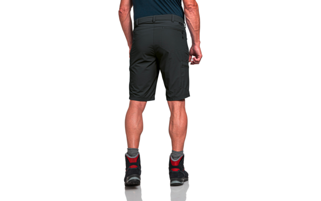 Rückenansicht einer stehenden Person von der Taille bis zu den Füßen, dunkle knielange Shorts, dunkle Schuhe mit roten Akzenten und graue Socken