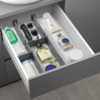 Geöffnete Schublade mit Zahnpflegeartikeln, darunter eine Zahnbürste, Zahncreme, Zahnseide, Mundspülung und Rasierer