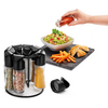 Draaibare plaat met kruiden, hand giet dressing over salade, frietjes op zwarte mat