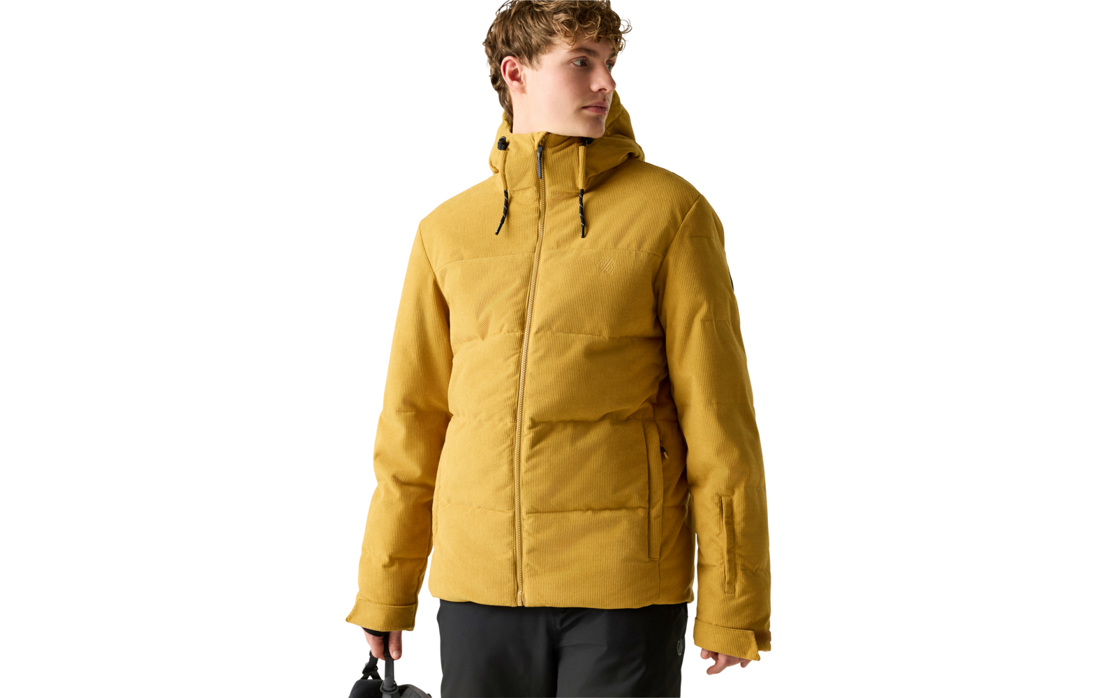 Person in gelber gesteppter Kapuzenjacke und schwarzer Hose, hält eine schwarze Tasche in der linken Hand, schaut nach rechts, heller einfarbiger Hintergrund