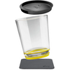 Clear drinking glass tilted, yellow ring at the base, black silicone lid above, square dark coaster below