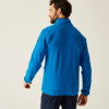 Mann von hinten in blauem Pullover vor hellem Hintergrund
