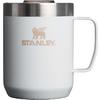 Witte beker met handvat rechts, zilverkleurige roestvrijstalen rand bovenaan, gestructureerd oppervlak, goudbeige 'STANLEY'-woordmerk en symbool op de voorkant