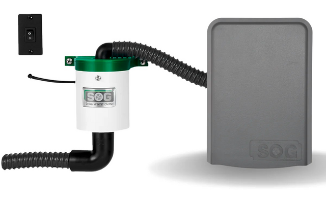 Pequeño dispositivo técnico con mangueras negras y caja gris sobre fondo blanco