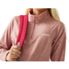 Vrouw met rode rugzak en roze trui kijkt naar rechts
