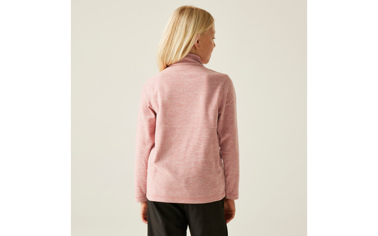 Frau mit blonden Haaren, von hinten, trägt rosa Pullover und schwarze Hose