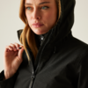 Frau mit schwarzer Jacke und Kapuze blickt nach rechts