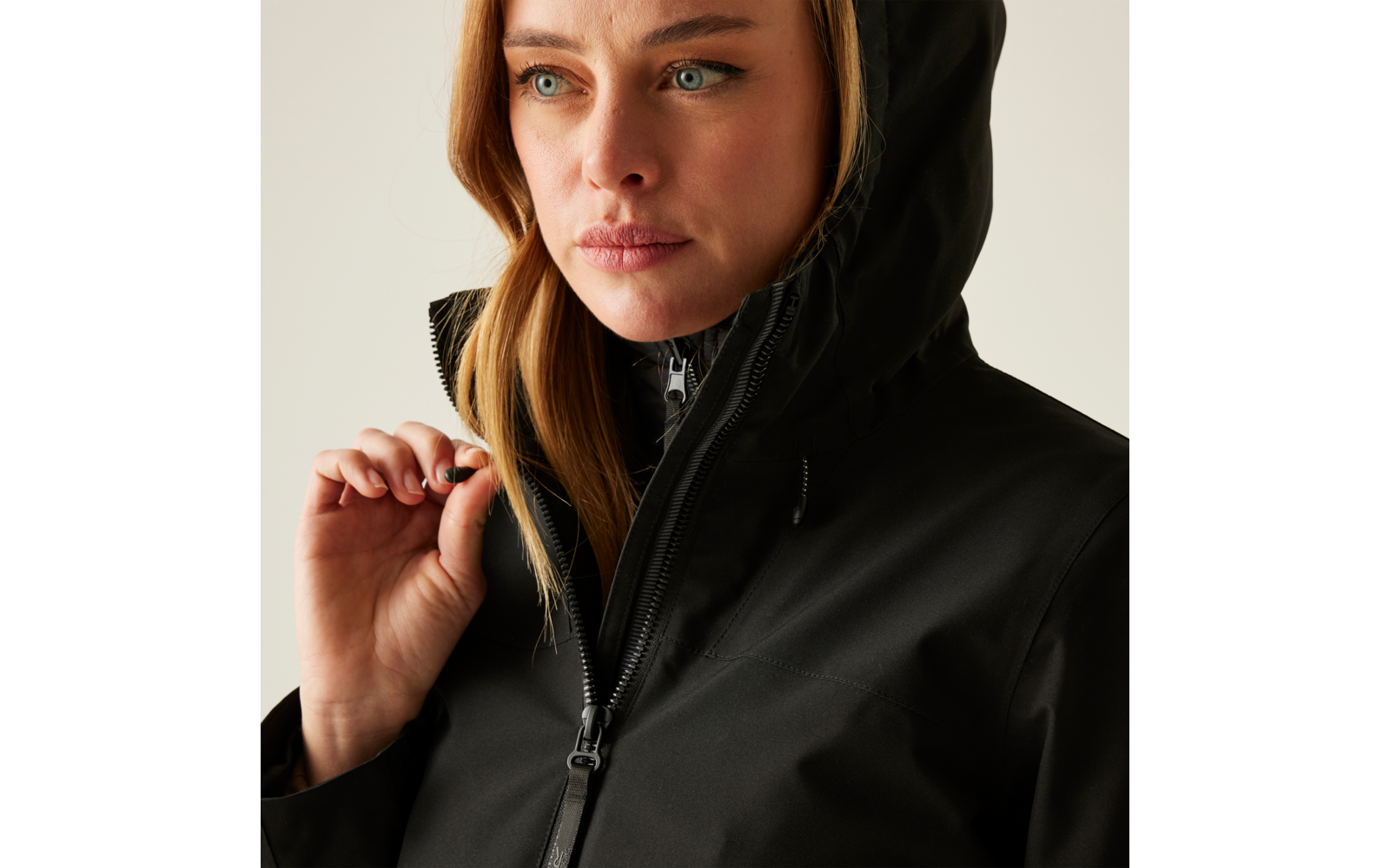 Frau mit schwarzer Jacke und Kapuze blickt nach rechts