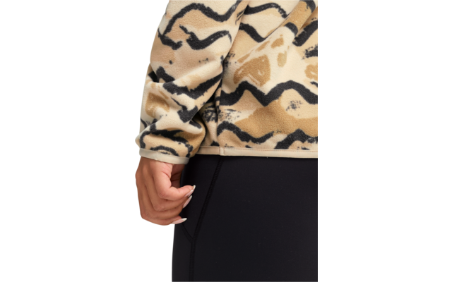 Nahaufnahme einer Hand an der Hüfte. Beige gemusterte Fleecejacke und schwarze Leggings sichtbar