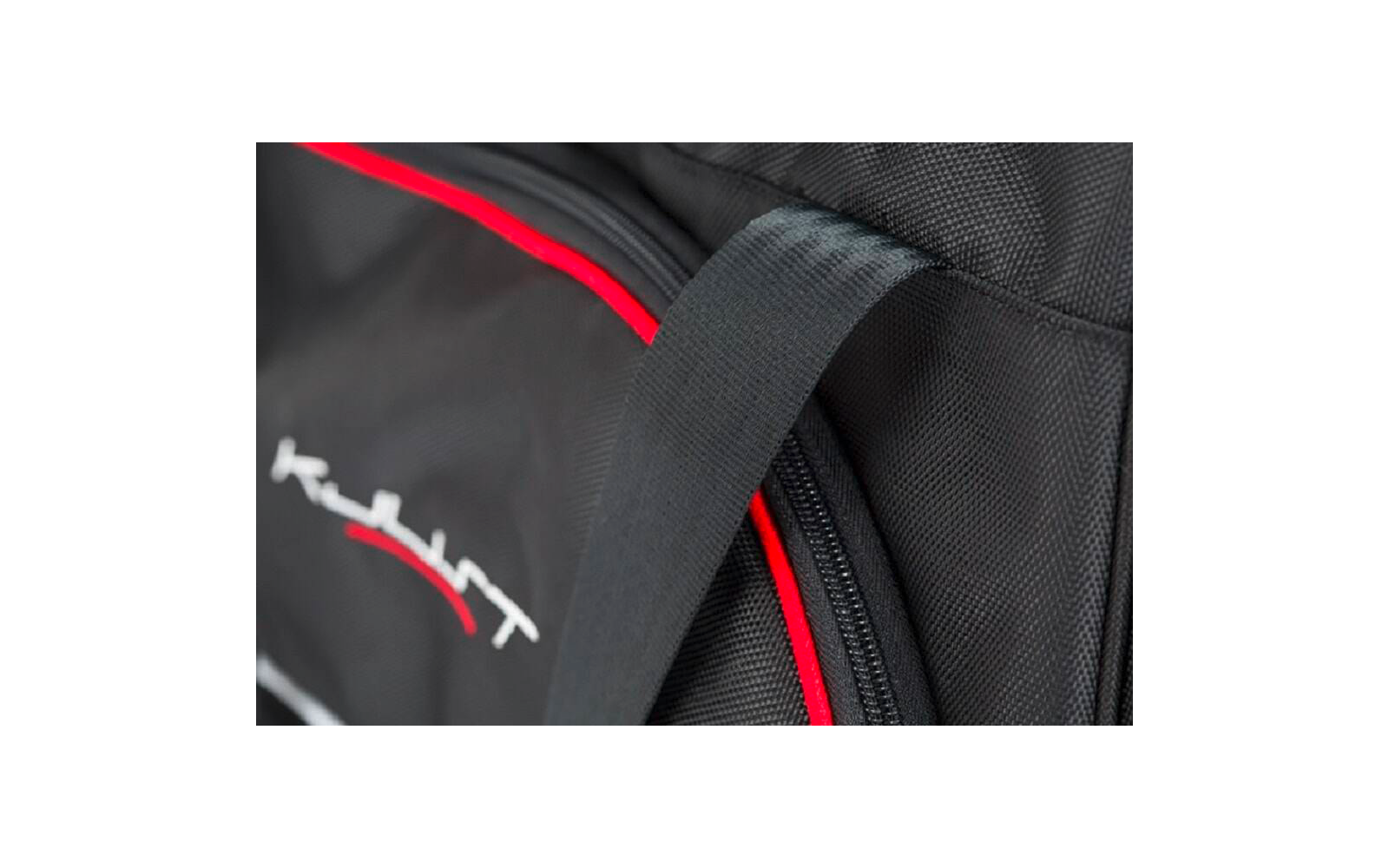 Nahaufnahme eines schwarzen Rucksacks mit roter Paspel, sichtbarem Reißverschluss und Tragegriff