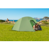 Tenda da campeggio verde su un prato con rocce e mare sullo sfondo, persona sdraiata davanti alla tenda