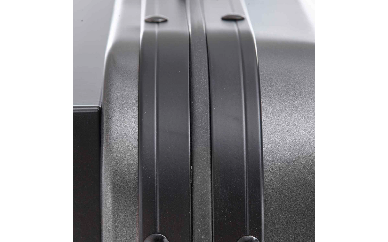 Nahaufnahme der Mittelnaht einer grauen Hartschale mit zwei parallel verlaufenden Rillen und sichtbaren Nieten