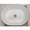 White oval sink with a central round drain hole and thin black rim on a light surface, wooden board visible at bottom