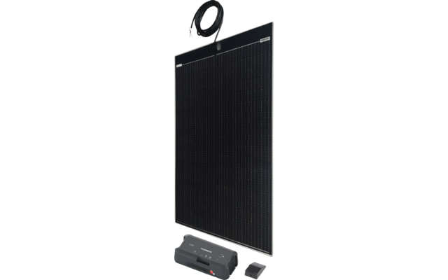 Schwarzes Solarpanel mit silbernem Rahmen steht vertikal; oben hängt ein schwarzes Kabel mit Steckern; davor liegen ein größeres graues Gerät mit Anzeige und Anschlüssen und eine kleine schwarze rechteckige Box