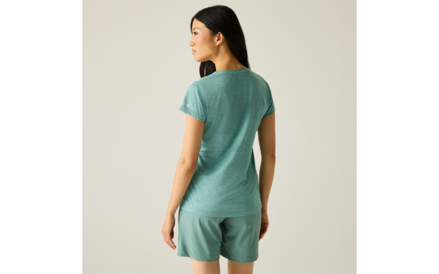 Vrouw van achteren gezien, draagt een turkooiskleurig T‑shirt en bijpassende korte broek, kijkt naar links voor een lichte achtergrond