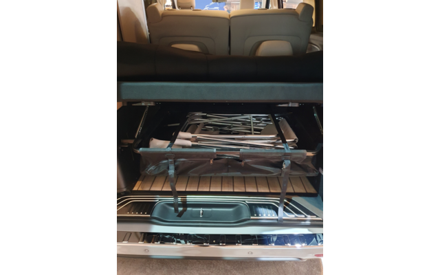 Offener Kofferraum eines Fahrzeugs mit hochgeklappten Rücksitzen und einer zusammengeklappten Metallkonstruktion mit Stoffteilen und Gurten