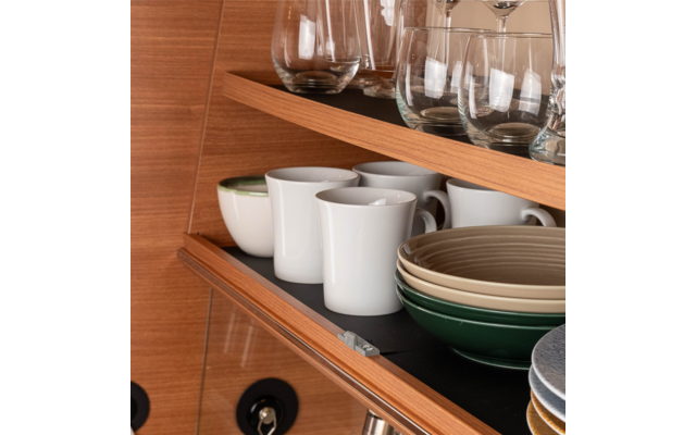 Open kitchen cabinet with white mugs, bowls, and glasses