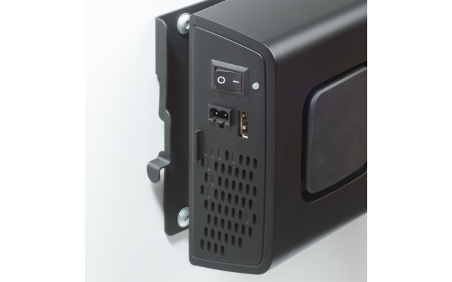 Schwarzes elektronisches Gerät an Wandhalterung, Seitenansicht mit Ein-/Ausschalter, USB-Anschluss, kleinem Stromstecker, Lüftungsöffnungen und sichtbaren Schrauben
