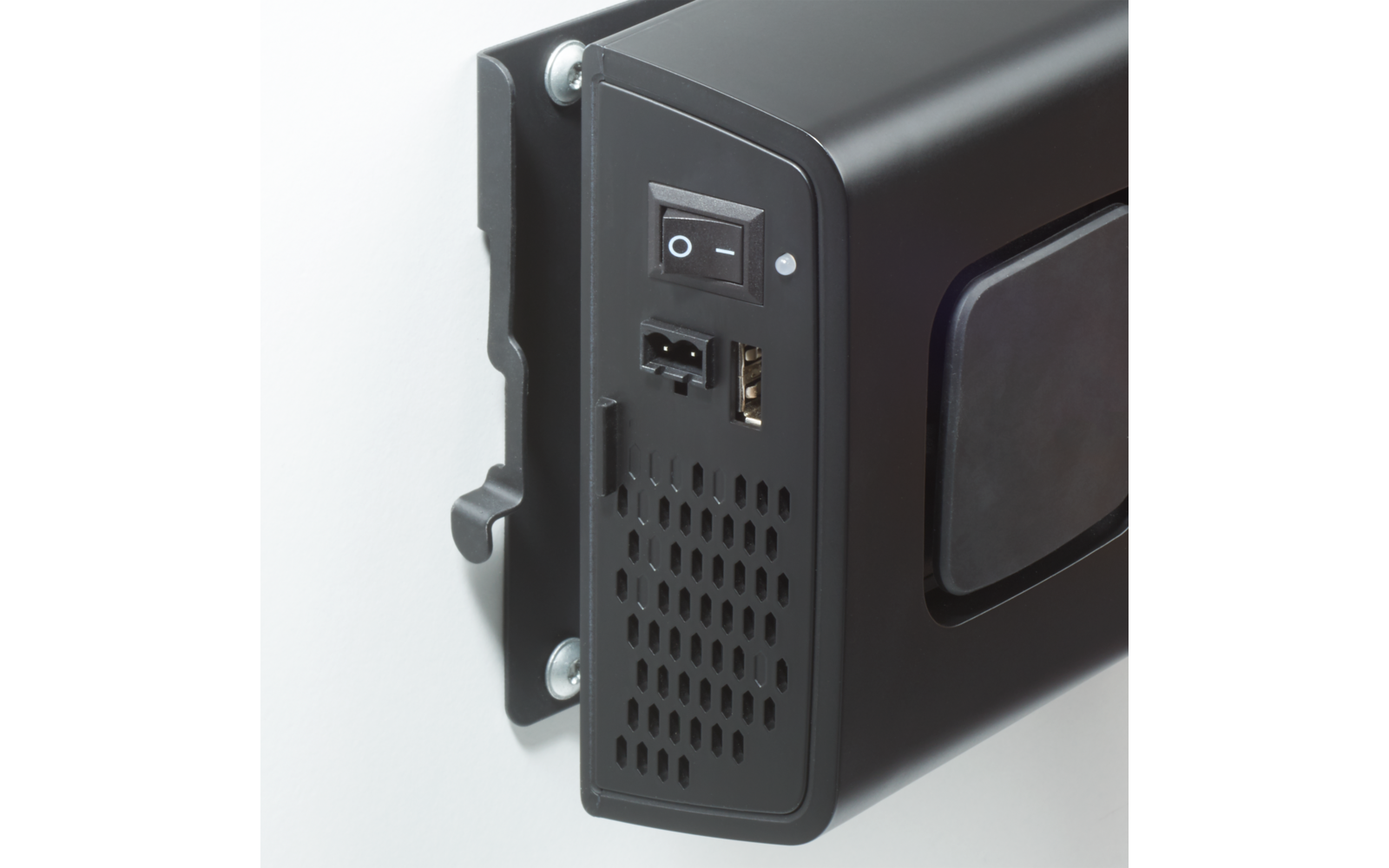 Schwarzes elektronisches Gerät an Wandhalterung, Seitenansicht mit Ein-/Ausschalter, USB-Anschluss, kleinem Stromstecker, Lüftungsöffnungen und sichtbaren Schrauben