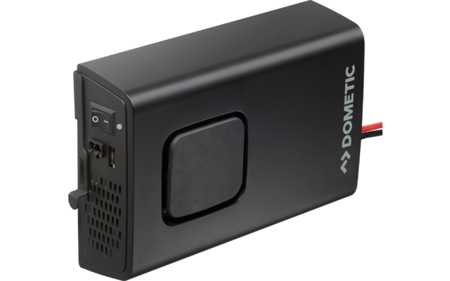 Schwarzes, rechteckiges elektronisches Gerät mit abgerundeten Kanten; rechts der Schriftzug "Dometic"; links Ein-/Ausschalter, Anschlussbuchsen und Lüftungsöffnungen; mittig ein quadratisches, leicht vertieftes Feld; rechts führen rote und schwarze K