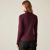 Femme vue de dos portant un haut à manches longues violet foncé et un pantalon noir sur un fond clair