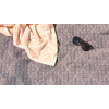Handtuch und Sonnenbrille auf gemustertem Stoff liegend