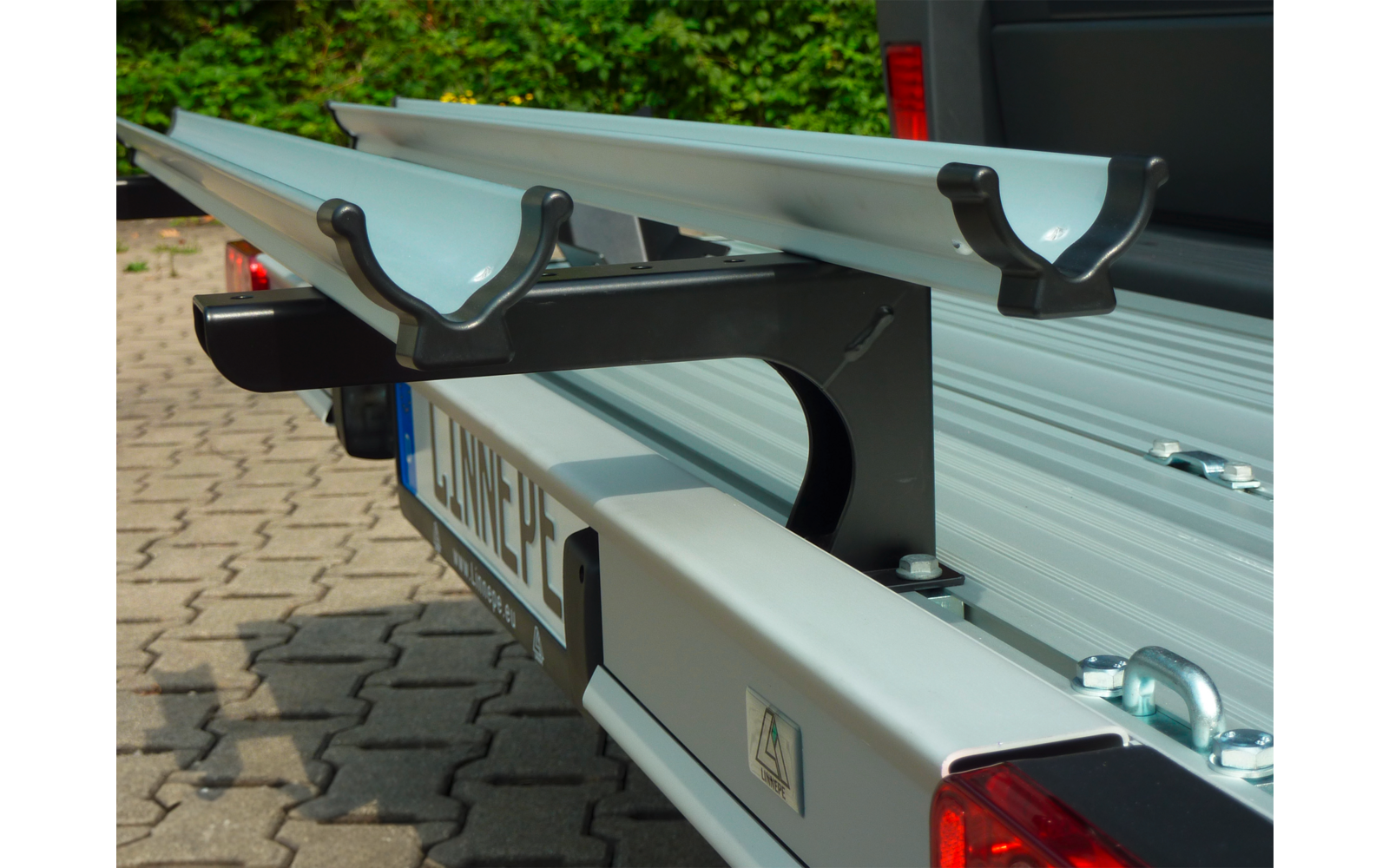 Twee zilveren aluminium profielen op een transportplatform met een groene achtergrond
